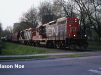 The CN 15:30 Kitchener Job is pictured approaching John Street in Waterloo, Ontario as they return from Elmira with seven cars on the Waterloo Spur with 7030 and 4141. At the time, the job only operated with two units when it was necessary and on this day, both Nutrite and Sulco Chemicals in Elmira had received several cars. The springtime was always a busy period for Nutrite receiving hoppers.