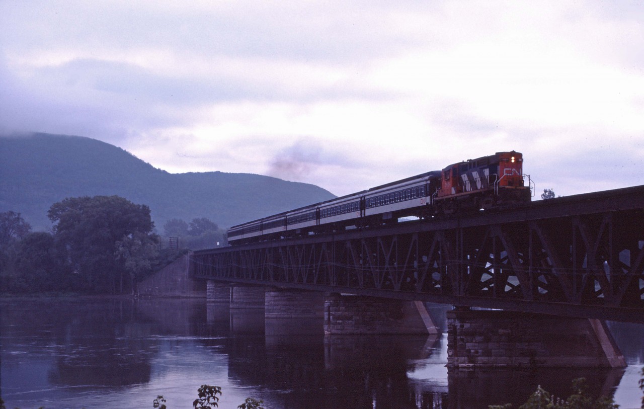 CN RS18 leads a six-car commuter train over the Richelieu River slowing for its Beloeil station stop. On this last day of August 1984, the train faces an uncertain future--it has not been included in the take over of the Deux Montagnes and CP Lakeshore commuter trains by the Montreal Urban Community (MUC) and, indeed, this train and its evening counterpart (No. 900) will make their last runs four years from now (9 September 1988).