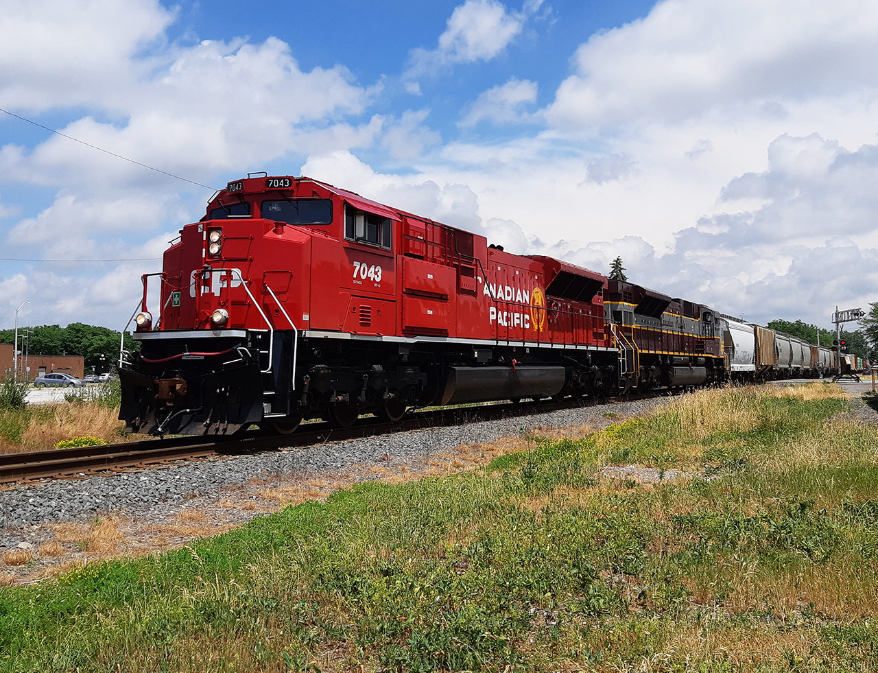 BIG RED AND A SCRIPTED FONT! I can't remember when I shot this photo, other than knowing I was on my lunch break from work. It was also sometime after CP rebuilt their stored SD90 units. But, this day in particular, was one every railfan waited for. There was an eastbound that was going to be coming, with two painted CM&Q units leading the charge. 


Here, rebuilt SD70ACu 7043 leads, along with a heritage unit in the vintage CP paint scheme, westbound through downtown Chatham.