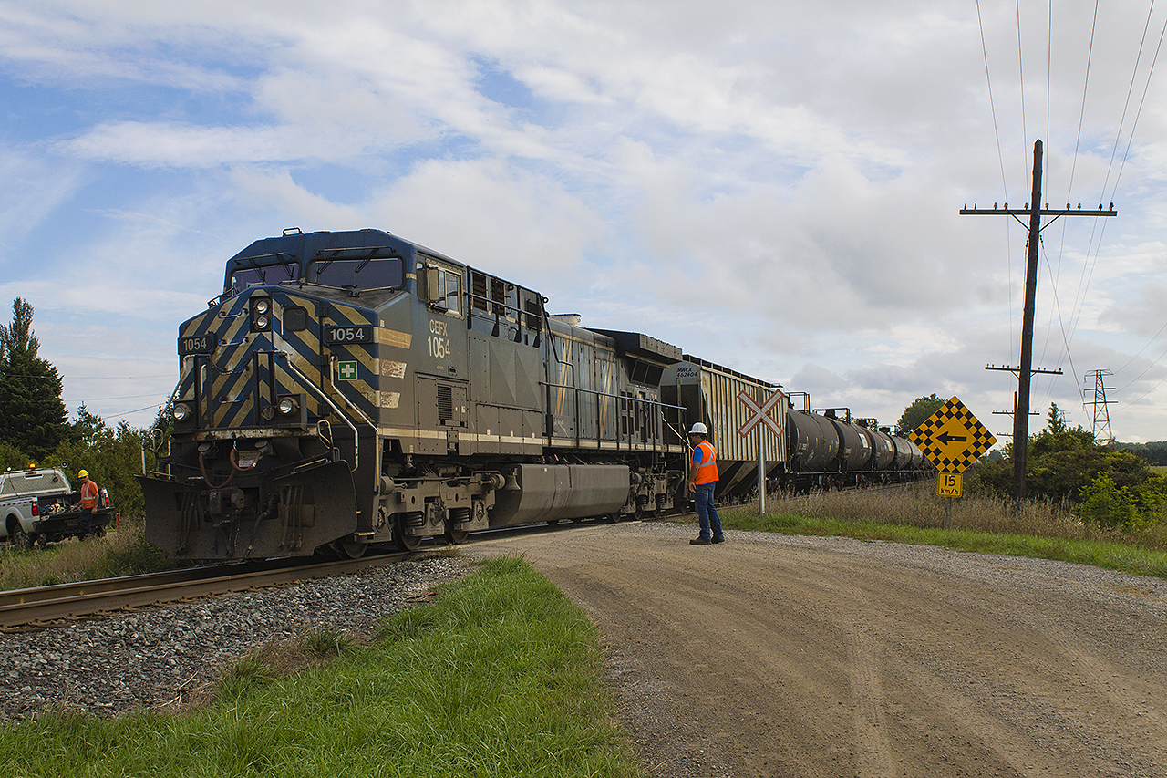 Back in 2017, CP started upgrades to their infrastructure. Here, the railways employees were replacing signs and wooden planks for the crossing at Third Line. Sure enough, any time can be train time. CP train 650 heads east, with CEFX 1054 as the rear DPU passing by under the careful inspection of the crew.