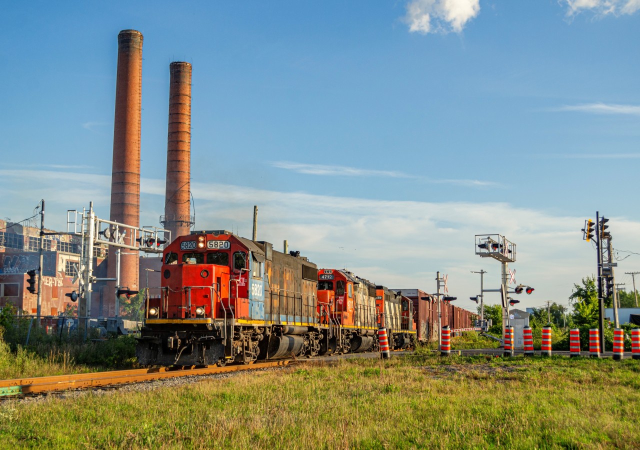 CN Switcher YRP003 heads back to Rivière-des-Prairies with about 8 boxcars in tow and a rather ratty GTW GP38-2 locomotive to pull them, as it passes by the former Dickson incinerator, now abandoned for nearly 50 years, located on the street bearing the same name.