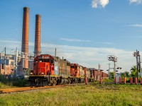 CN Switcher YRP003 heads back to Rivière-des-Prairies with about 8 boxcars in tow and a rather ratty GTW GP38-2 locomotive to pull them, as it passes by the former Dickson incinerator, now abandoned for nearly 50 years, located on the street bearing the same name.