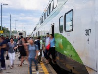 Passengers are seen disembarking their evening GO train at Etobicoke North station and walking to the parking lot to drive the remainder of the trip home or to catch a bus on Kipling Ave below.