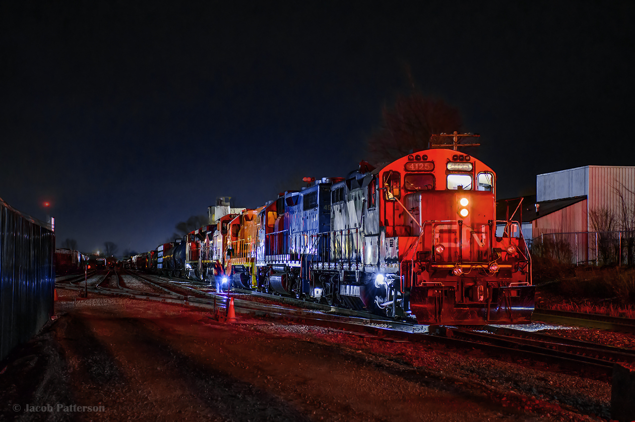Its half past midnight at Kitchener yard.  The last GO trains of the evening have cleared the area, and freight action is well underway.  L566 slipped out to the Waterloo Spur behind 4906, 7068 shortly before this scene, rushing to clear up and give L533 access to the yard, while L587 with 4125, 4902, and HESR 3510 sat on the ladder.

With 533 in the siding and their engineer changing ends, 587 tacks the 3510 onto 533's power for movement to G&W's RailSynergy Oshawa operation, then ducks back into the yard to allow the Toronto crew to shove clear of the plant and make their runaround move to the east end of their lift.  587 will begin breaking up the inbound cars as soon as they've cleared the lead.