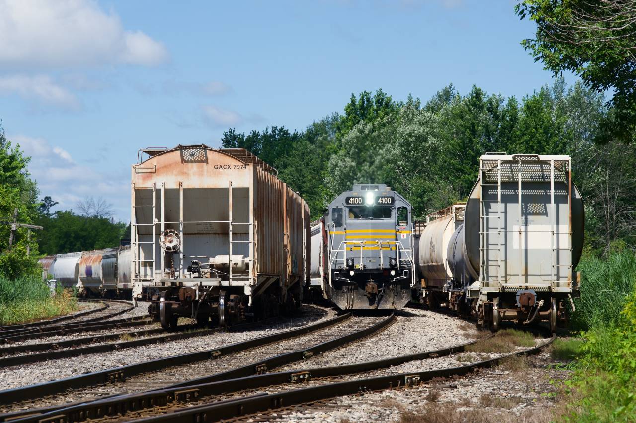 CN 538 with IANR 4100 leading is backing up between some cars near Coteau Station.