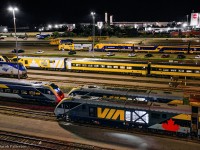 The early morning hours at VIA's Toronto Maintenance Centre find numerous pieces of equipment at the ready for upcoming departures to Ottawa, Montreal, Windsor, and New York.  The new Siemens Charger sets make up the majority of the scene, including "LUMI" at centre, with stored Budd equipment in the distance beyond the newest delivery or Siemens equipment.  Ontario Northland's third and final set of equipment, ONT has just been delivered by and is seen being positioned by VIA 903 after a brief stop at the fuel pad.  Note freight equipment from CN L543 in the distance, waiting for the pair of geeps to turn on the wye before returning to Oakville.