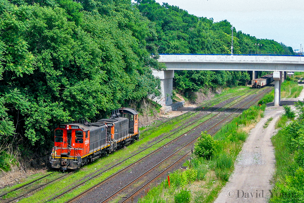 Returning from "The Hole" one of SOR's jobs returns to Stuart Street with a pair of former CN SW1200RS'. The power has uncoupled from their haul and retreat to the yard, running under the branches over hanging the yard lead. A crew member can be seen in the distance on the cars waiting for the go ahead to release the hand brake and drop their pull into the yard, saving time and a run around move. Once the cars have cleared the engines the crew will begin switching out the yard.