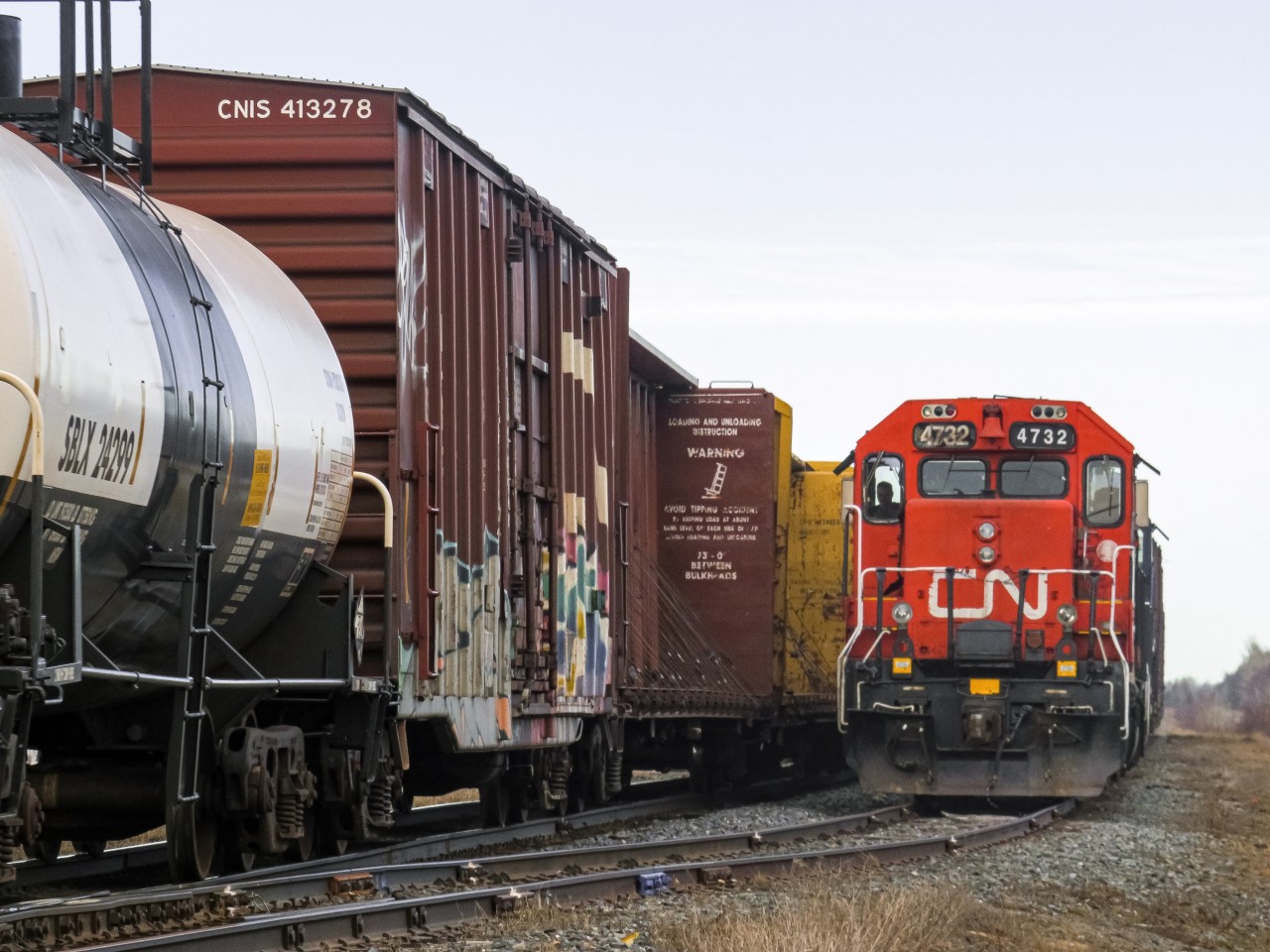 CN local train 559 waits in L'Isle-Verte siding for train 402 to clear, minutes after completing its work at April Lubricants, hidden by 402 in the background. Today, these meets doesn't happen anymore, as 402 doesn't run daily anymore, and train 559 is almost always sent on days which the mainline freights doesn't run. CN 4732 has also since been modernized with an electronic bell and an ekyrail A/C unit.