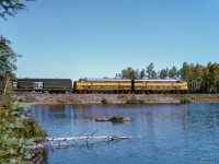 The weekend of September 13 - 15, 1963 marked a massive undertaking by the Upper Canada Railway Society, a 692.2 mile excursion from Toronto - Ottawa - North Bay - Temagami - Toronto, with seventeen coaches behind CNR 6167. With the train having run overnight from Toronto - Ottawa on the 13th, the train turned west and departed the nation's capital early on the 14th, running across northern Ontario to North Bay. 6167 would be removed at North Bay, with ONR FP7s handling the train to Temagami overnight. The consist returned to North Bay on the morning of the 15th, with 6167 taking over once again for the return to Toronto.

<br><br>About halfway back to North Bay from Temagami, passengers have detrained for a runpast, as the pair of green and yellow FP7s rumble past Moose Lake at approximately mile 28, just north of the community of Tomiko.

<br><br>Further information can also be found in <a href=https://railwaypages.com/upper-canada-railway-society-ucrs-and-its-publications>the December 1963 UCRS news letter.</a>

<br><br>The saga:
<br><a href=https://www.railpictures.ca/?attachment_id=54615>Ottawa Arrival</a>
<br><a href=https://www.railpictures.ca/?attachment_id=55753>Ottawa Dominion</a>
<br><a href=https://www.railpictures.ca/?attachment_id=57853>CNR 6167 in the capital</a>
<br><a href=https://www.railpictures.ca/?attachment_id=55181>Running across the north</a>
<br><a href=https://www.railpictures.ca/?attachment_id=54757>Sleek steam</a>
<br><a href=https://www.railpictures.ca/?attachment_id=56096>Morning at Temagami</a>
<br><a href=https://www.railpictures.ca/?attachment_id=59431>Jocko runpast</a>
<br><a href=https://www.railpictures.ca/?attachment_id=54806>North Bay arrival</a>

<br><br><i>Scan and editing by Jacob Patterson.</i>