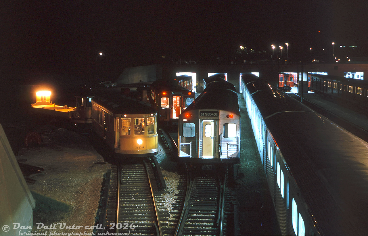 An assortment of TTC subway equipment gathers by the shops at Davisville Yard at night in the Summer of 1963, as seen from the still-active CN Belt Line Branch bridge spanning the yard. The brand new 5300-series MLW M1's were only aluminum subway cars on the property at the time (the first H1's wouldn't arrive until 1965), and they're mingling with the original "Red Rocket" steel Gloucester "G" cars built in the 1950's, dating back to the 1954 opening of the Yonge line. The University subway line had opened earlier that year, and "St. George" on the rollsign reflects the new western end terminus of the combined Yonge-University line (no Spadina extension until 1978). Yellow-painted work equipment lingering around includes RT-4, former Peter Witt streetcar 2528 converted for garbage collection on the subway, and an unknown dump car behind (possibly RT-3).

For a more modern 2008 view of this area of Davisville Yard: https://www.railpictures.ca/?attachment_id=59740
Original photographer unknown, Dan Dell'Unto collection slide.

Note: the photographer of this image is unknown, but judging from the labeling and date stamp, they also took photos of streetcars at Bloor and CP near at West Toronto on their 1963 visit to Toronto.