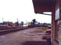 On a hot July afternoon one could feel the humidity after a brief downpour. Being only 4 years old at the time, my grandfather took this photo of a mid-afternoon VIA train, heading west to Toronto.

You will note that the two tracks in the foreground, is the 'actual' Kingston Sub. CN realigned the tracks due to the construction of the Centre Street underpass, and installed a temporary level crossing just behind us to divert traffic. 
