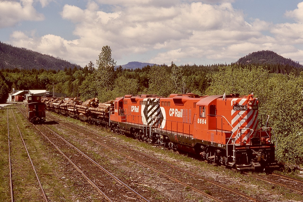 Clean GP9s CP 8664 and 8502 are shown on Friday 1979-05-18 at Lake Cowichan, assembling a train of log loads from Crown Zellerbach’s Nitinat Logging Division, hence the nickname Nitinat for such moves to Crown Zellerbach’s log dump into the saltchuck at Ladysmith.  The E&N depot at Lake Cowichan is to the right and behind my photo perch, and it survives to this day as the Kaatza Museum, slightly relocated from its original spot.