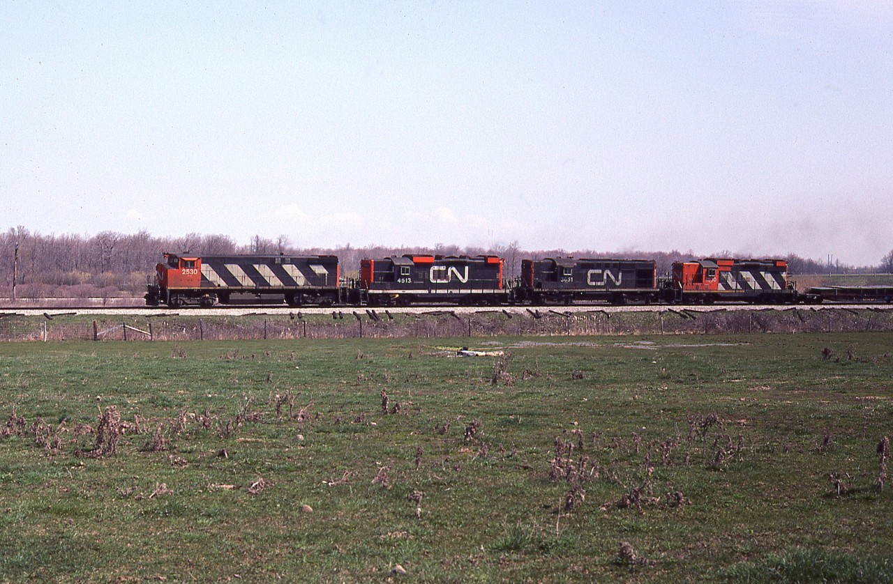Four units up front on this westbound CN freight out of Fort Erie is interesting with the paint variations. The photo was taken from Curtis Rd, a short gravel stretch just to the west of the QEW. Power is CN 2530, 4513, 3651 and 4530. Lead unit was renumbered 3530 in 1986.