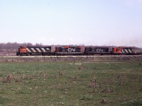 Four units up front on this westbound CN freight out of Fort Erie is interesting with the paint variations. The photo was taken from Curtis Rd, a short gravel stretch just to the west of the QEW. Power is CN 2530, 4513, 3651 and 4530. Lead unit was renumbered 3530 in 1986.