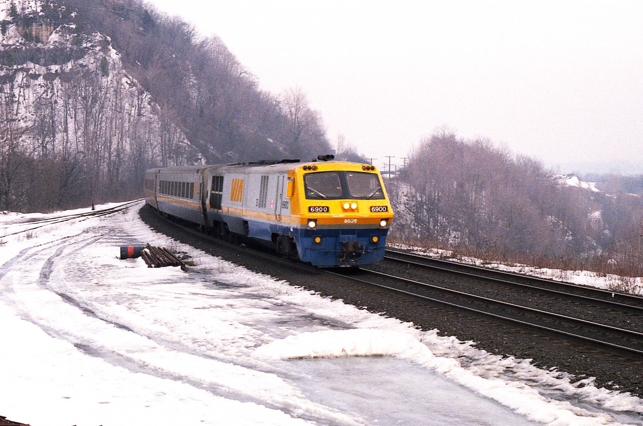 The head of a rather unforgettable class is seen rounding the bend by Dundas Peak heading westbound. The Bombardier LRC-2 (and -3) series were a period probably many VIA brass would rather forget. They were failure prone in so many ways, being overly high tech for their time. Engine leaks & failures, vibrations at speed; long runs at high speeds and harsh winters really did a number on them. The LRC-2 and -3 series did not last long on VIA, most of them not more than a dozen years.
When I first saw them; I thought "ugh", but now that their day is long gone, the old photos create historical interest.  Production run was from 6900 to 6930.