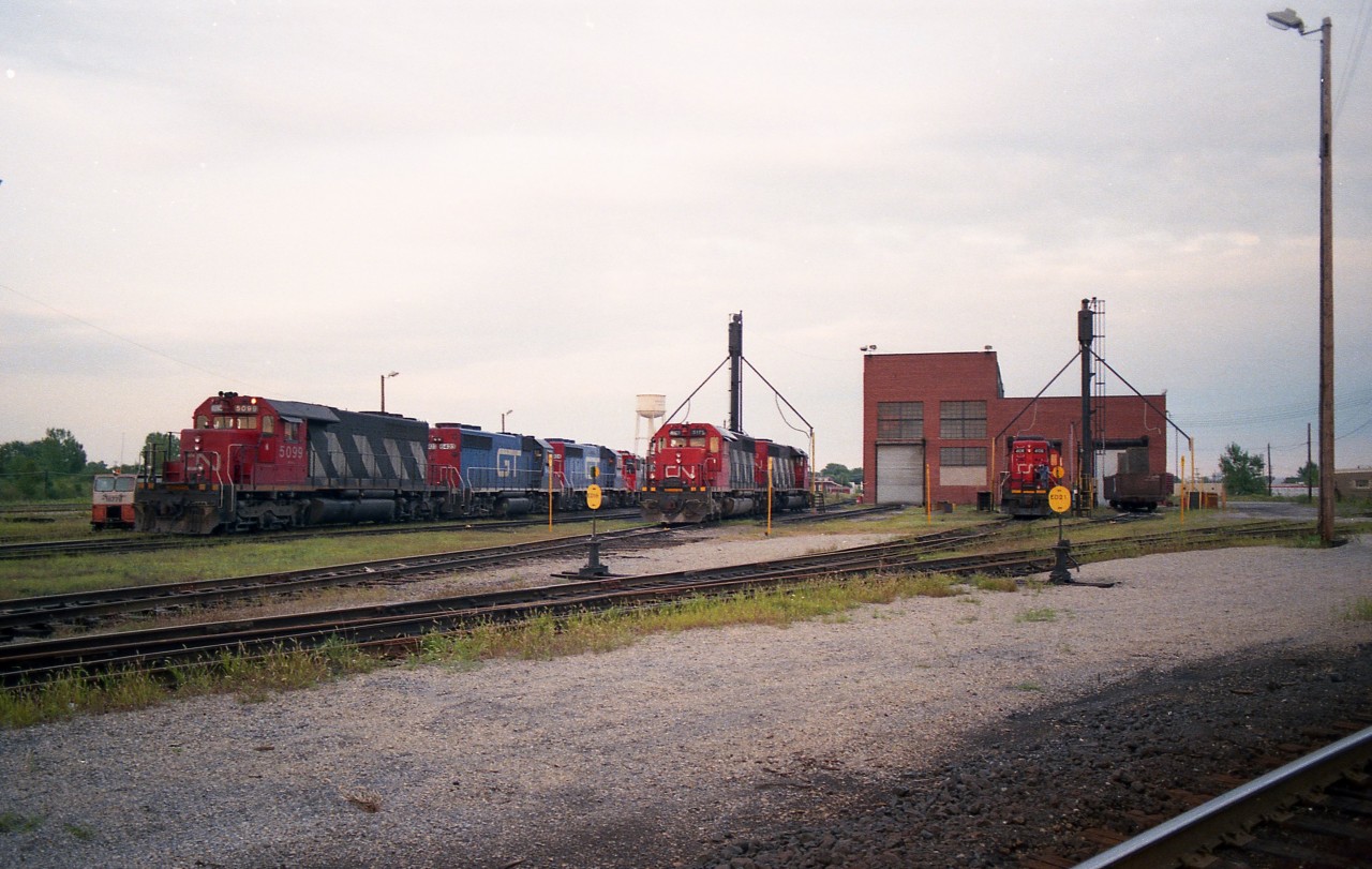I submitted this just as a "refresh the memory" image. The CN Fort Erie diesel shop used to be such the interesting place to visit. Almost anything CN could be found from one day to the next, including locomotives such as the two GT noted here. From the left; CN 5099, GT 6424, 6423, CN 7306. Centre is CN 5175, unknown behind it, and what appears to be 4018 on the right.
Of interest too is the 8 man gang motor car CN 187-78 on the extreme right, Fairmont Railway Motors Model A4, built 1975. (This information, of course, from Paul O'Shell)
Heavy work wound down in 1987 and the shop facility closed for good in 1989.
Niagara Railway Museum opened utilizing this building in 2010 and now has an interesting collection of rolling stock and artifacts. Check on-line for information.