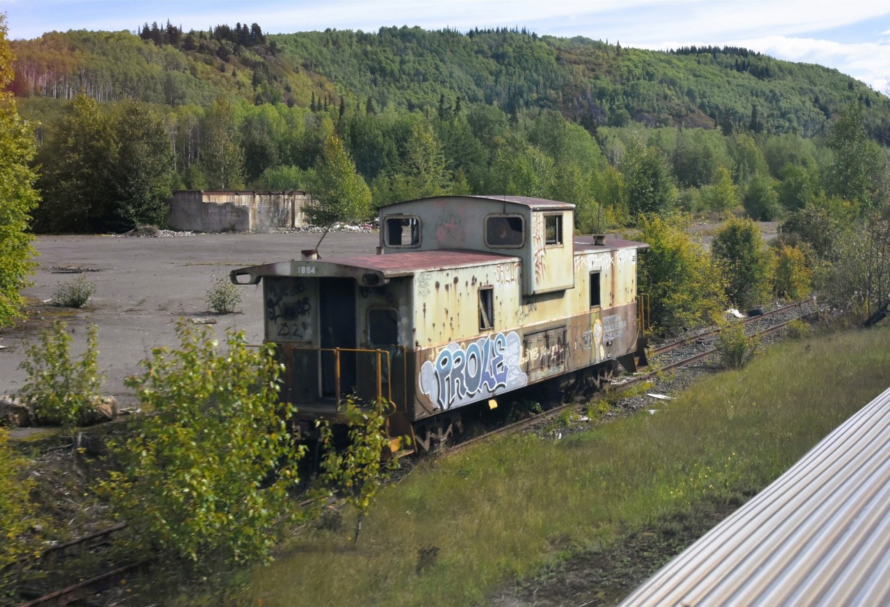 Forlorn Van   
BCOL 1884 sits abandoned on an overgrown backtrack in the BC interior along CN's Bulkley Sub. near Andimaul, BC.  
Searching the internet, I read that BCOL 1884 was the cab on the last caboose equipped train on BC Rail that departed Fort St. John for Fort Nelson on August 12, 2004. 
My photo is 22 years later on September 4, 2026. 
BC Rail, CN, and VIA Rail all represented in this photo. Location approximate.