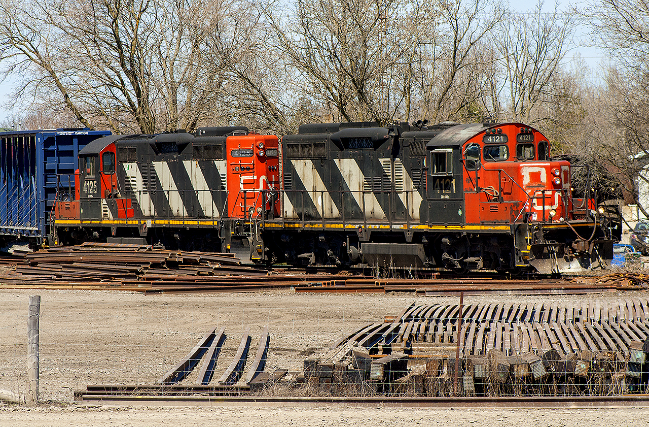 Nothing like a cool, sunny Spring morning. Although I was on my way to Napanee, I made a day out of stopping at certain locations that never usually disappoint in terms of 'action'. 


Here, CN veterans 4125 and 4121 are bringing back a cut of cars. The trackage they're on I believe connected at one point to the old Canadian Northern main. This would've been back before the creation of CN. When the CNoR and GTR became CN, I believe that CN reconfigured some of their industrial tracks using the former CNoR main line. After all, it was just a few hundred meters away. 


Also, note the stacks of rails, ties and other 'junk' that these engines are passing. This is the former 'yard' at the station. All removed, when VIA built a behemoth pedestrian bridge with new platforms.