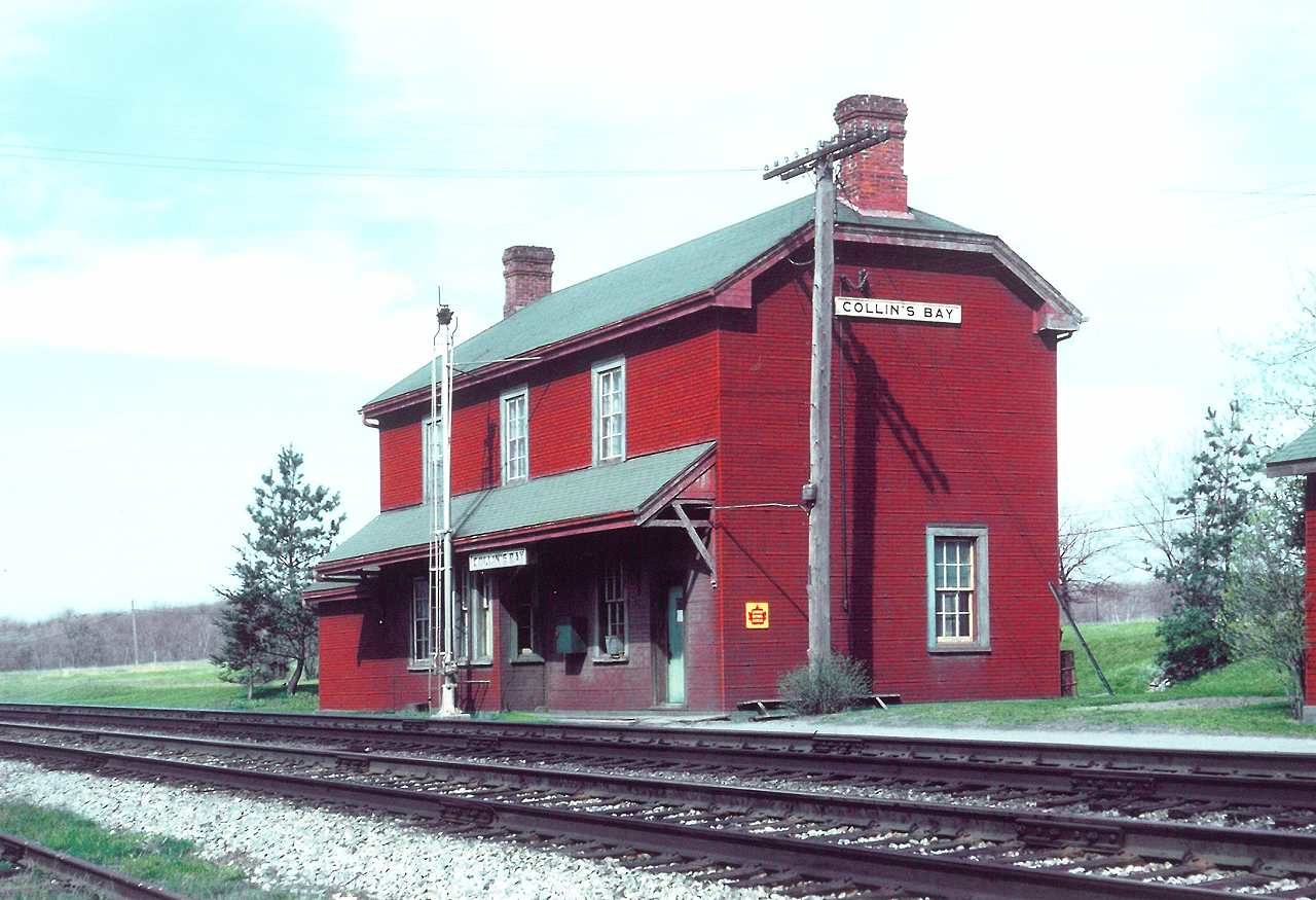 For all Station Masters...


CN Collins Bay station, circa late 50s or early 60s. Green shingled roof, well worn insulbrick that's starting to peel and fade, and a train order signal removed. 


Of interest...


Those who looked after the trains through this town always referred 'going down to the Bay', due to this section of mainline having many curves, on a grade. Behind the station, still looks empty with no sign of any suburb being built (today's Aylmer Crescent neighbourhood).


As time moved on, the decline in ridership continued, with the improvement of highways and the railways infrastructure to stay competitive. And with the new 'outer' Kingston station having been built with realignment away from the old  Montreal Street outer station  CN focused more on  eliminating the stops 'in between'. After all, the new station was built in a closer proximity to the stop in Collins Bay.


Thus, the end came around 1974 when the station was demolished. All that remains today, is a little avenue across from Edith Rankin United Church appropriately called 'Station St.' 


And it's at about this location, on the north side of the tracks being west of Collins Bay Road crossing, this large structure once stood. 


Photographer Unknown, photo provided by the late Dave Savage, Canadian Railway Station News.