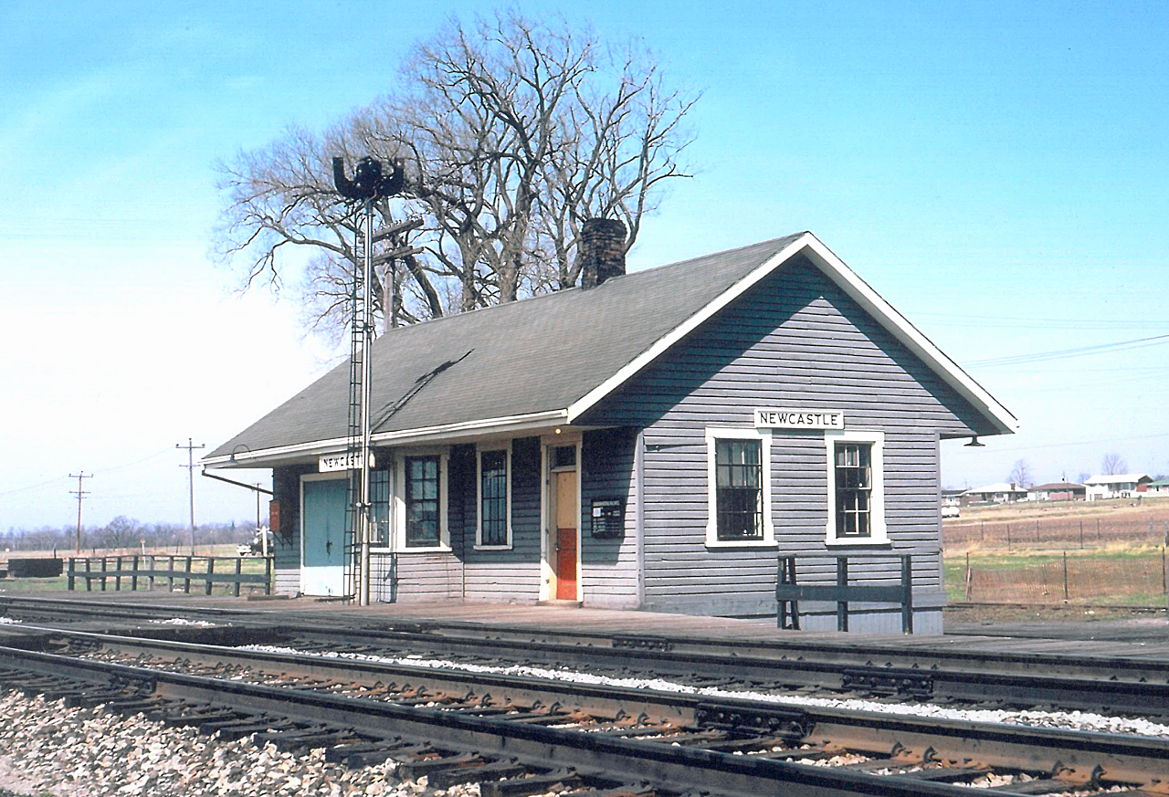 Caption: 


Once home for the Massey family, this village was incorporated in 1856. Coincidentally, during the same year the Grand Trunk Railway completed its line, initially building a limestone station, similar to those still standing at Port Hope, Napanee and Prescott. 


CN Newcastle Station, circa 1960.


For those who have pit stopped at the 401 On Route west of Port Hope, you would've viewed a mural of the full structure at its peak. This was the second structure, as it replaced the limestone structure when the GTR double tracked their mainline. By now, the large baggage area was truncated as traffic started to decline. 


Bonus to those who can identify the year and make of the pickup, travelling along Toronto Street - today, it's an industrial park.


For the full history, you can go to the  THRA website. 


 Photographer Unknown, photo provided to me by the late Dave Savage, Canadian Railway Station News.