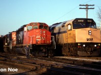 An evening CN 395 is pictured in the yard at Kitchener, Ontario after taking the siding for VIA 89, which is seen passing as it heads to London over the Guelph Subdivision. Powering 395 are SD40-2(W) 5317 and GTW SD40-2 5930, which would soon begin lifting their loaded auto frame cars, once the 15:30 Kitchener Job would clear the yard with GP9RM 7030. The auto frames were manufactured at the massive Budd automotive frame plant in Kitchener situated on the Huron Park Spur.