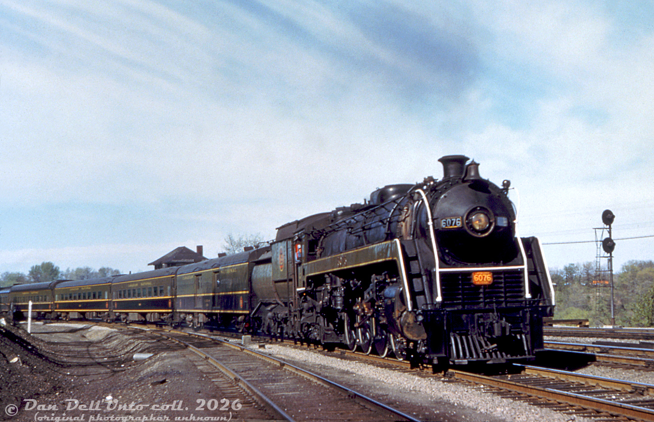 Canadian National Railway "Bullet-Nosed Beatty" 4-8-2 6076 (U1f class, built by MLW in 1944 and scrapped in 1960) swings around the curve at Bayview Junction with a westbound passenger train from Toronto. It's seen coming off the CN Oakville Sub and starting the climb up the Dundas Sub. The old Bayview Junction interlocking tower that was once here is partially visible over the second car. In the foreground was the old steam helper track.
Original photographer unknown (duplicate slide), Dan Dell'Unto collection slide.