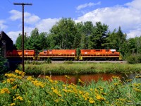 The tranquility along the shores of the La Vase River is briefly interrupted by squealing steel on this late summer afternoon. Ducking beneath CN’s Newmarket North sub, Ottawa Valley Railway F61 departs North Bay for the 85 mile run to Mattawa with 29 cars for Rayonier Advanced Materials’ mill in Temiscaming, Quebec.  A week after this photo, <a href=https://www.nugget.ca/news/temiscamings-ryam-plant-closing-its-industrial-complex-sept-15-400-unionized-workers-affected>RYAM would announce the indefinite idling of the Temiscaming mill</a> on account of 50% tariffs imposed by the American government.


<br><br>The Kipawa Mill was constructed at Temiscaming circa 1918 - 1919 by the Riordon Pulp and Paper Company, which had also acquired the nearby 1888 Lumsden Sawmill.  The site would come under control of the Canadian International Paper Company (CIP) in 1925, and continue until 1972 when CIP would close the mill.  It was revived in 1973 under the name Tembec, a company largely founded by the mill's former employees, which ran until being bought out by Rayonier Advanced Materials in 2017.

<br><br>Further information can be found in the 1975 National Film Board documentary <i><a href=https://www.nfb.ca/film/temiscaming-quebec/>Temiscaming, Quebec.</a></i>