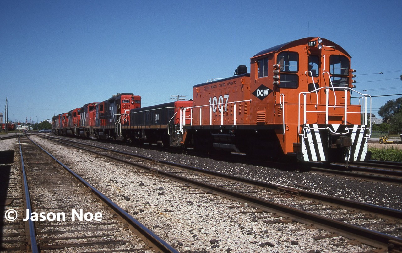 During the summer of 1996, Dow Chemical sent SW1200 1007 from their Fort Saskatchewan facility to their plant in Sarnia, Ontario. At the time, in return Dow transferred S-6 1001 from Sarnia to Fort Saskatchewan after only being in Sarnia since arriving in 1993. Eventually Dow closed their Sarina plant, and it was torn down with SW1200 1007 eventually being acquired by VIP Rail in Sarnia.

Here 1007 is pictured on route to its new home on train 399 at London. The consist included; 9504, GTW 6410, 5013, 9582, 7208, 218 and DOW 1007.