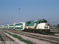 A short GO Transit consist lingers at the west end of Willowbrook Yard, made up of GO GP40TC 505 and four bilevels including a cab car. This consist is a little bit smaller than a regular revenue train, perhaps it was a special or test train for some occasion. The red K3L air horn suggests a swap by CP shop forces at some point, possibly while it was leased to CP in freight service. In the background, the tall chain-link fences of the Mimico Correctional Centre off Horner Avenue can be seen.<br><br>505 was one of eight specially-built GMD GP40TC (Toronto Commuter) locomotives constructed in 1966 for the Government of Ontario's new commuter service, but at this point in 1988 they were all on borrowed time. With new GMD F59PH units rolling off the assembly line in London, GO 505 and her siblings had already been put up for sale earlier that year in May, and would depart for Amtrak in October, hastily renumbered into their new numbers 192-199.<br><br><i>Peter Jobe photo, Dan Dell'Unto collection slide.</i>