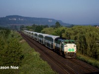 An early morning eastbound GO train is viewed entering Milton, Ontario on the CP Galt Subdivision where it will make it’s first station stop of the day, loading commuters for the trip into Toronto. At the time, all the GO trains on the CP line were based out of the Guelph Jct layover facility and every weekday morning, the eastbound parade of five empty train sets would descend the Niagara Escarpment into Milton about a half hour apart. 