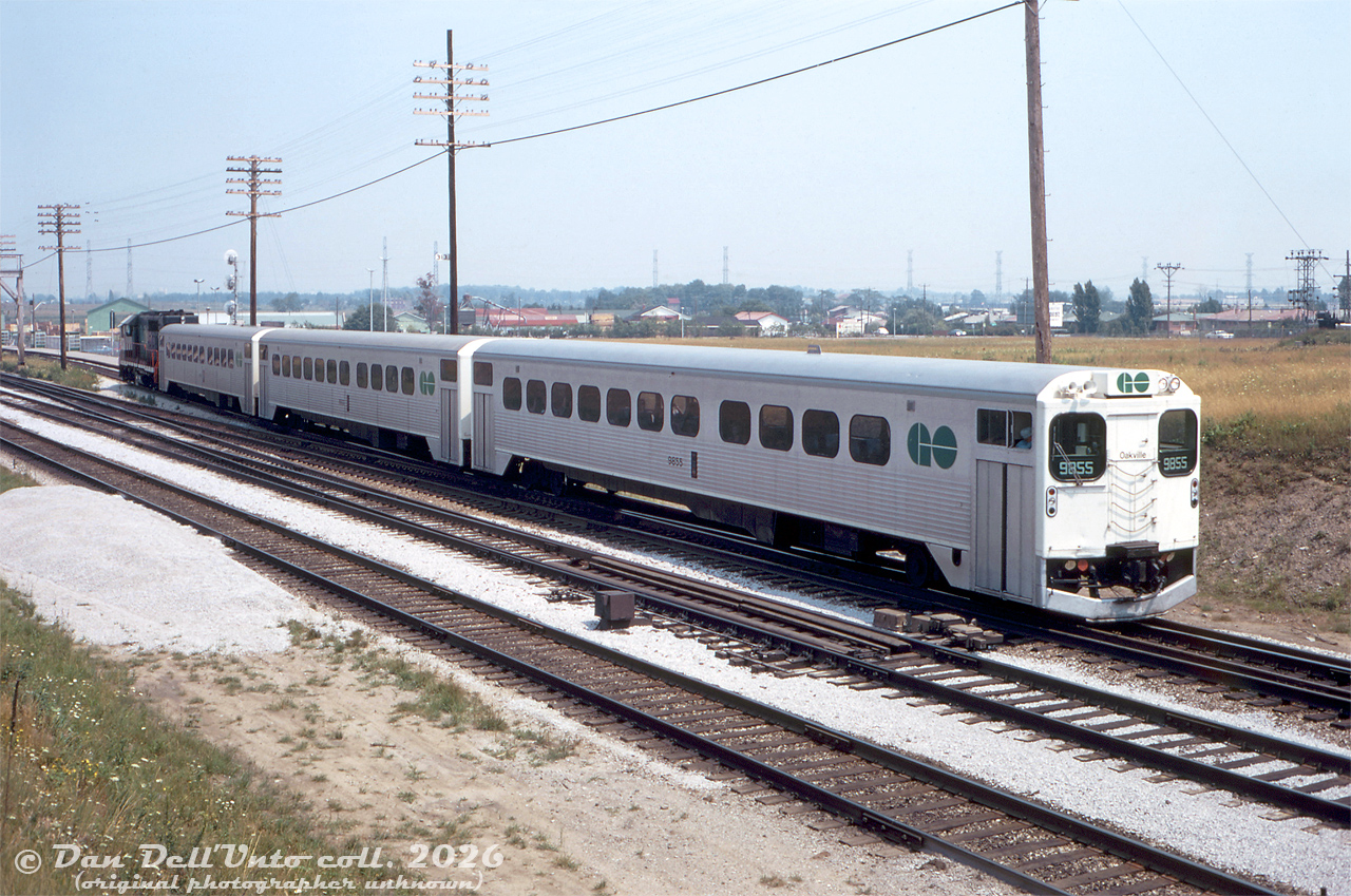 A short train of GO Transit single-level Hawker Siddeley cars ("GO Karts") pulls out of the commuter lead at Pickering GO Station, heading westbound on the CN Kingston Sub in Lakeshore line service. GO cab car 9855 leads two other cars, with GP40TC 9807 pushing on the tail end (locomotive view here).Original photographer unknown (possibly a John H. Eagle photo), Dan Dell'Unto collection slide.