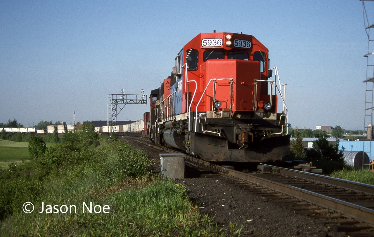 During a spring evening, GTW SD40-2 5936 and GP40-2L(W) 9575 lead a westbound CN intermodal train through Milton, Ontario at Milbase on the Halton Subdivision.