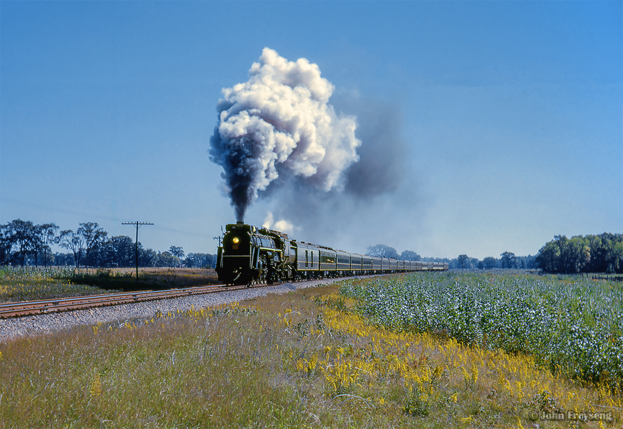 The weekend of September 13 - 15, 1963 marked a massive undertaking by the Upper Canada Railway Society, a 692.2 mile excursion from Toronto - Ottawa - North Bay - Temagami - Toronto, with seventeen coaches behind CNR 6167. With the train having run overnight from Toronto - Ottawa on the 13th, the train turned west and departed the nation's capital early on the 14th, running across northern Ontario to North Bay. 6167 would be removed at North Bay, with ONR FP7s handling the train to Temagami overnight. The consist returned to North Bay on the morning of the 15th, with 6167 taking over once again for the return to Toronto.

At roughly mile 47.5 pf the Beachburg Sub, CNR 6167 swings through the sweeping curve at Bristol, Quebec, following the north shore of the Ottawa River from the capitol into the northern wilderness before crossing back into Ontario near Beachburg.

Further information can also be found in the December 1963 UCRS news letter.

The saga:
Ottawa Arrival
Ottawa Dominion
CNR 6167 in the capital
Running across the north
Sleek steam
Morning at Temagami
Jocko runpast
Tomiko runpast
North Bay arrival

Scan and editing by Jacob Patterson.