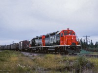 Canadian National's only two GP35 units, recently released from GMD London, lead a westbound train over the diamond with the Algoma Central at Oba, meeting southbound ACR train 2, out of view at left.<br><br><a href=https://www.railpictures.ca/?attachment_id=54251>Pausing at the station</a><br><a href=https://www.railpictures.ca/?attachment_id=59048>The head end</a><br><a href=https://www.railpictures.ca/?attachment_id=59651>The ACR/CN meet</a><br><br><i>Scan and editing by Jacob Patterson.</i>