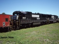 During a hot summer afternoon, Norfolk & Western caboose 555019 along with Norfolk Southern C39-8 8617 and C36-7 8531 await their next call to duty at the CN yard in St. Thomas, Ontario. Van 555019 was one of several NW cabooses assigned to Canada. 