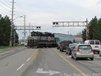Orangeville-Brampton Railway's high-nose GP9 of choice, CCGX 1000, snarls traffic on Mississauga Road near downtown Streetsville as it switches the CP-OBRY interchange at Streetsville Junction. The unit is setting off its short train of 6 cars (two covered hoppers and four tank cars) before running around to the north end of the interchange track and lifting five covered hoppers for the trip back north.<br><br>I had shot this train coming down through downtown Brampton down at the diamond, and beat it down to Streetsville just as it was arriving, nabbing it at Alpha Mills Road. Since the train was tying up Mississauga Road making its setoff, I remember I had to quickly loop around some of the side streets, swiftly park and bail out at the now-closed Streetsville Beer Store (there's a politician somewhere to blame for that), and then walk out into traffic for this quick "Don't get hit by a car today Dan" shot, as the Geep was just backing into the clear, I needed to be on the left side of the road, and oncoming traffic was getting impatient. After a <a href=http://www.railpictures.ca/?attachment_id=5178><b>few more photos</b></a> here, it was back up to Brampton just in time for VIA #85 and the northbound OBRY run returning back to Orangeville (with no time for a quick stop at Credit Valley in downtown Streetsville for more Intermountain hoppers today).