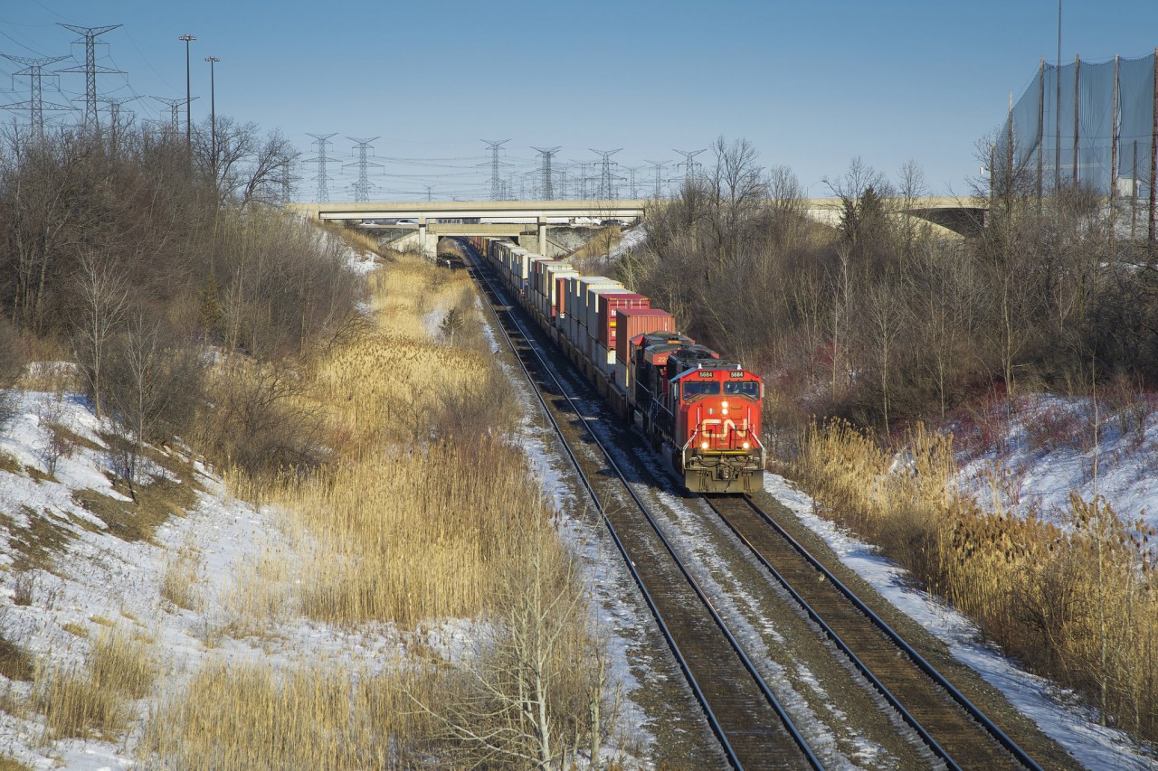 CN hotshot Q149 cruises downhill into the Humber River valley on the Halton Subdivision bound for Brampton Intermodal Terminal for work. There, no.149's power will be flipped, Montréal traffic will be dropped for Toronto, and Chicago stacks are lifted for the trip west to Chicago Markham.