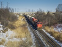CN hotshot Q149 cruises downhill into the Humber River valley on the Halton Subdivision bound for Brampton Intermodal Terminal for work. There, no.149's power will be flipped, Montréal traffic will be dropped for Toronto, and Chicago stacks are lifted for the trip west to Chicago Markham.