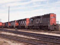 Dearly beloved, we are gathered here together.......... well not quite... actually, these CN  GMD GP40s are collected in town for their official renumbering.
Seen in a row in the yard are CN 9306, 9307, 9302, 9310 and others. They had previously toiled in the 4000 series. Built in 1966/67, they were retired or sold by 1998.