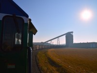 It was rather invigorating to be invited up into the cab of PRMX 6973 for a run down to the Poplar River Power Generating Station, about 12 miles distant to the south.  In this image, we are loading and almost ready to depart the Poplar River Coal Mine. Not much out there to see, typical Saskatchewan grasses and a few gravel grade crossings until you get to the Hwy 18 crossing and the Generating Plant. Coronach itself, a village of about 650 people, lies a bit to the west.
The whole operation here is under control of Westmoreland Mining, LLC, and there is a chance it may be shut down by 2030. Tours of the mine itself are available in the summer months two days a week. Call ahead.