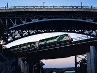 GO F59PH 551 brings an early morning rush hour train across the Desjardins Canal in Hamilton, on its way from Hamilton GO Centre to Toronto Union Station. This was a tricky shot to get with my Nikon F50 camera, as it was difficult to determine the correct aperture, speed settings and film type to capture the train without a blur in either the train or background from panning. The York Blvd. bridge is visible overhead, along with a bird and a biker on the way to their daily appointments. Highway 403 is in the background and the CN Grimsby/Oakville Sub directly behind me. It was a humid July morning, and the 551 was still in its factory paint shortly before its first overhaul.
