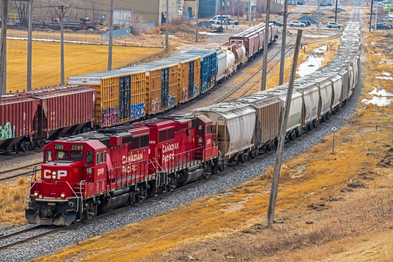 Looking down from Winnipeg's garbage hill, watching a CPKC train roll by heading back to their yard.