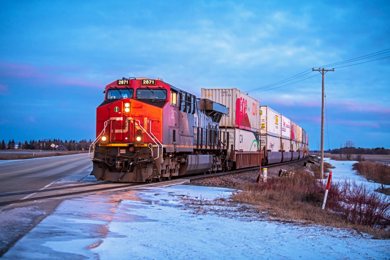 As the sun rises during the early spring, CN 2871 is leading their intermodel train into Eastern Manitoba