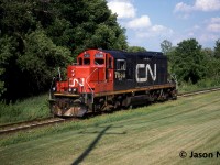During a July evening, the CN 15:30 Kitchener Job with GP9RM 7030 has just crossed Queen Street on the Huron Park Spur and is pictured heading to the Budd Plant light power. 