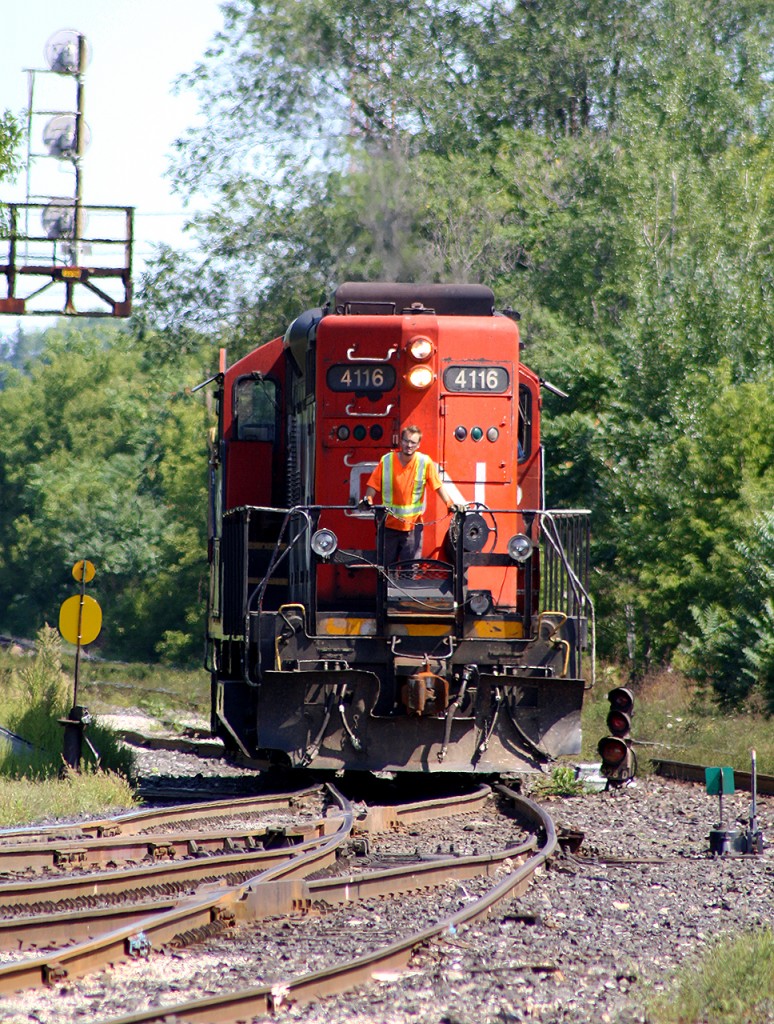 CN 4116 is seen switching in the yard, long nose forward. And, conductor standing perfectly poised on the platform. To the right, one can just see into view the  plaid shirt sleeve of the engineer.  I was told he always looked like that, but still gave me a wave when they finished their shift.