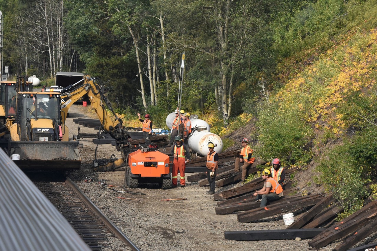 If you want to run trains, you have to do maintenance  
The crew of CN Construction Gang CW55 takes a break to conduct a roll-by inspection, and wave at the passengers aboard VIA 005 The Skeena as it rolls past their worksite at CN Wynd, AB Mile 2.57 Albreda Sub. just a few miles west of Jasper. 
A nice day to be retired and riding a train. Also a nice day to be working on the railroad.