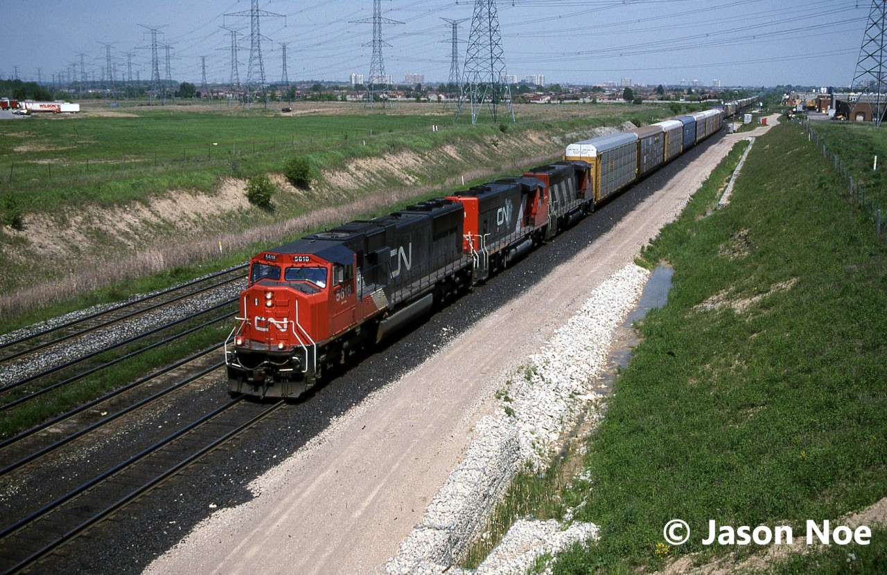CN train 271 is seen rolling through Snider on the York Subdivision in Vaughan, Ontario. The consist included; CN SD70I 5618 and GP40-2L(W)’s 9501 and 9627, which are slowing for a crew change ahead at Snider West. SD70I 5618 is less than a year old having been built by GMDD in London and delivered on October 7, 1995.