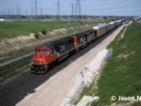 CN train 271 is seen rolling through Snider on the York Subdivision in Vaughan, Ontario. The consist included; CN SD70I 5618 and GP40-2L(W)’s 9501 and 9627, which are slowing for a crew change ahead at Snider West. SD70I 5618 is less than a year old having been built by GMDD in London and delivered on October 7, 1995. 