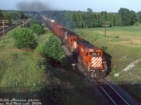 CP SD40-2 5995, SD40 5553 and a 4200-series C424 lead a long freight westbound on CP's Belleville Sub at Archer's Road, on the approach to Spicer (between Colbourne and Cobourg) on the outskirts of Colbourne. CN's Kingston Sub can be seen running parallel on the left.<br><br><i>Keith Hansen photo, Dan Dell'Unto collection slide.</i>
