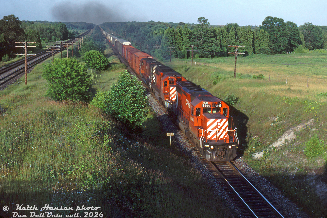 CP SD40-2 5995, SD40 5553 and a 4200-series C424 lead a long freight westbound on CP's Belleville Sub at Archer's Road at Mile 129, on the approach to Spicer (between Colbourne and Cobourg) on the outskirts of Colbourne. CN's Kingston Sub can be seen running parallel on the right.

Keith Hansen photo, Dan Dell'Unto collection slide.